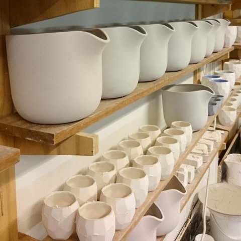 Flowerpots are drying on the shelf before these go into the kiln