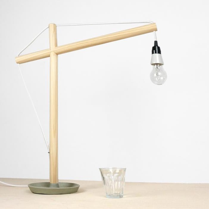 This desk lamp represents the shape of a construction crane. Made of wood and with a ceramic base