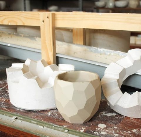 The poligon cup in front of the two piece mold that is used for casting